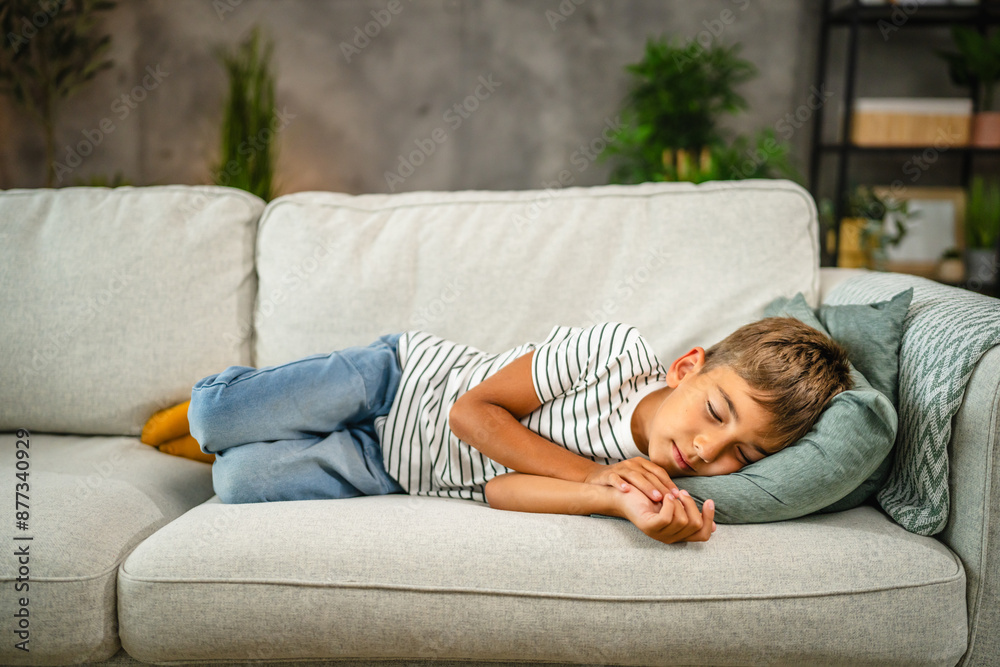 school caucasian boy have a afternoon nap on the sofa at home school caucasian boy have a afternoon nap on the sofa at home