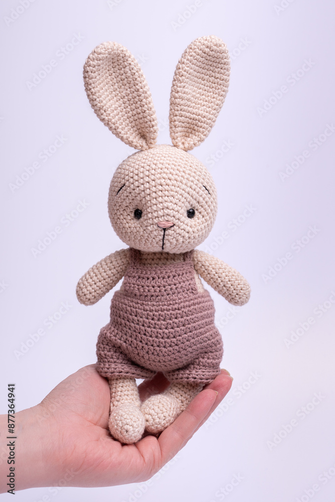 Handmade knitted amigurumi bunny toy on a white background. Handmade knitted amigurumi bunny toy on a white background.