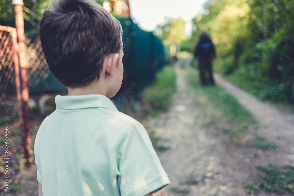 A young soldier watches his son before leaving for an overseas assignment. A boy waves to his soldier father as he sends him off to the army.