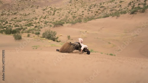 A man falls down the Singing Dunes in Altyn-Emel National Park, Kazakhstan. 