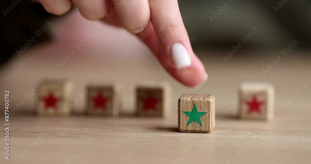 Hand of woman taking wooden cube with green star and putting forward on table. Concept of leadership and nonconformity slow motion Hand of woman taking wooden cube with green star and putting forward on table. Concept of leadership and nonconformity slow motion