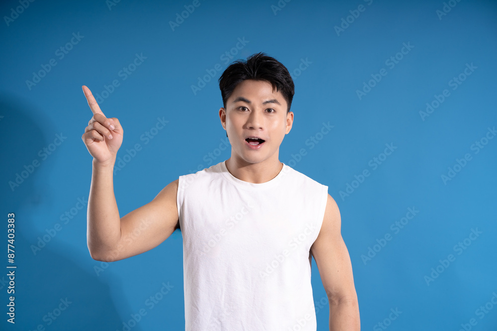 Portrait of asian guy wearing summer outfit and posing on blue background Portrait of asian guy wearing summer outfit and posing on blue background