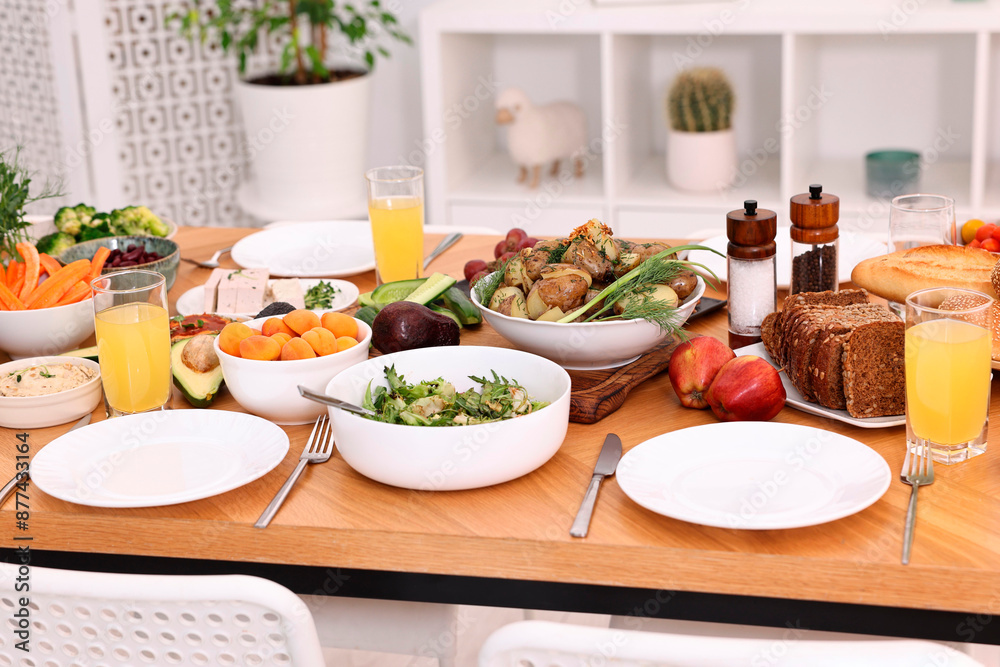 Healthy vegetarian food, glasses of juice, cutlery and plates on wooden table indoors Healthy vegetarian food, glasses of juice, cutlery and plates on wooden table indoors