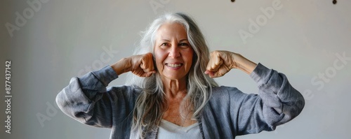 Obraz na płótnie Happy senior woman flexing muscles and smiling, showing strength and confidence. Free copy space. w salonie
