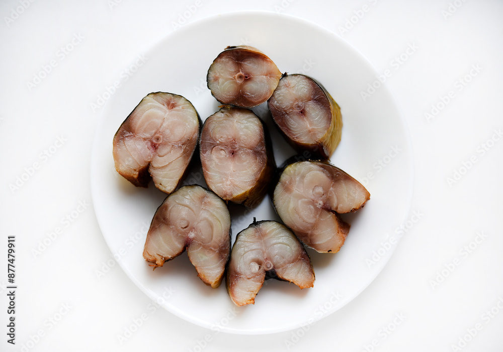 Sliced smoked Scomber on a white plate. Fish appetizer. Sliced smoked Scomber on a white plate. Fish appetizer.