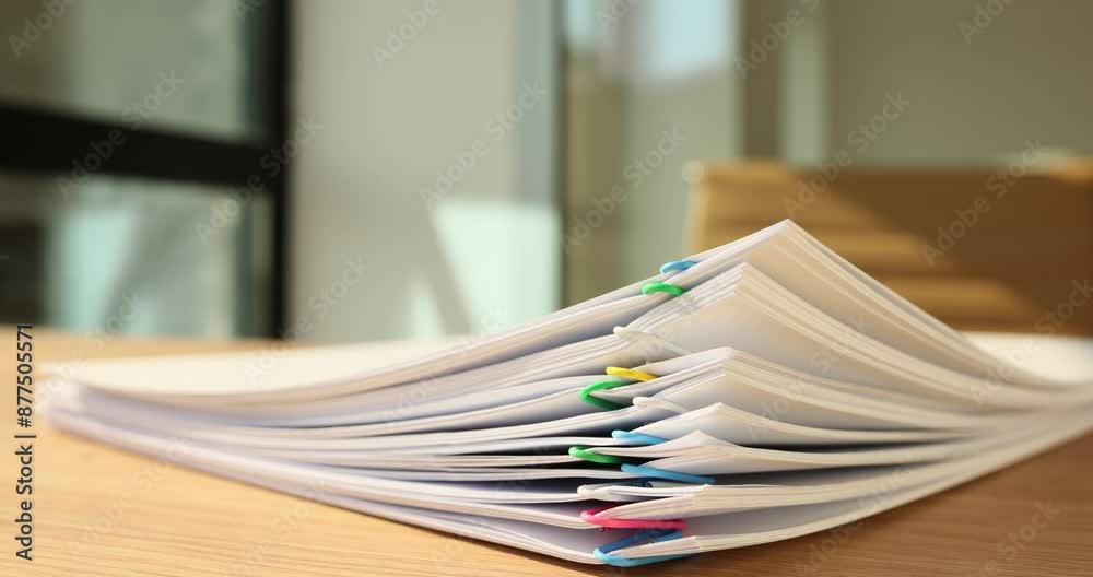 Time lapse of papers with multi-colored clips disappearing from wooden table in office. Stack of documents and accounting papers at secretary workplace