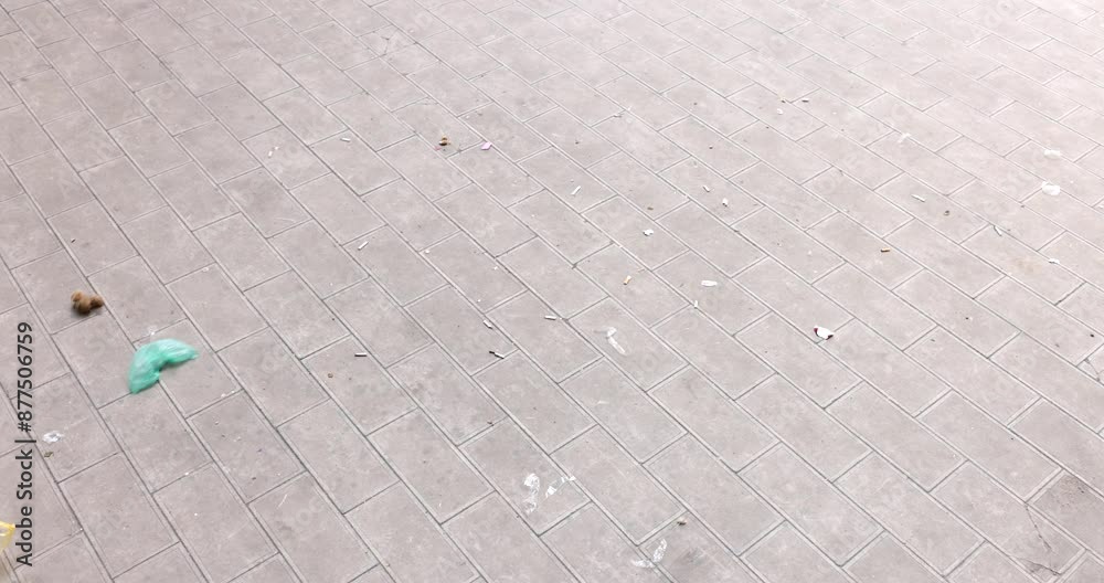 Colorful plastic bags and pieces of garbage fly on windy day. Strong wind throws trash on street pavement in city. Environmental pollution problems