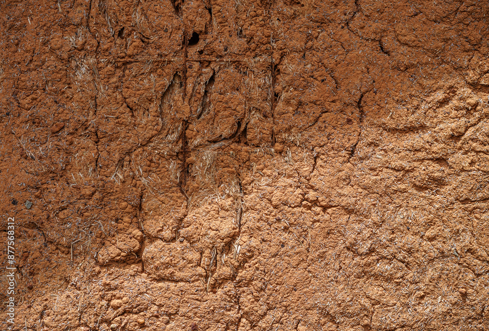 Structure wall of old mud house. Clay wall, surface texture. Close up.