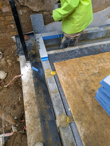 Thermal break in foundation walls with load-bearing insulation block at construction site. Structural foundation work and energy-efficient building design.