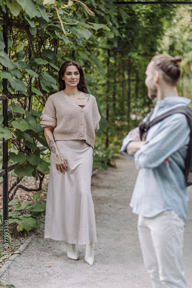 Copy space. overs are laughing. Happy guy and girl. Lovers enjoy each other in the evening park. Happy romantic moments of lovely couple in park during dating. Girl with tattoos.