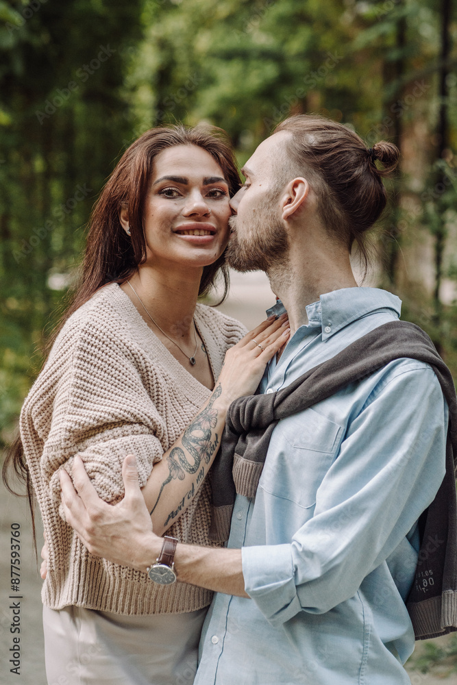 Fototapeta premium Love, hug and happy with couple in park for romance, bonding and summer vacation. Loving young couple hugging and smiling together on nature background. Beautiful girl with tattooed body outdoor.