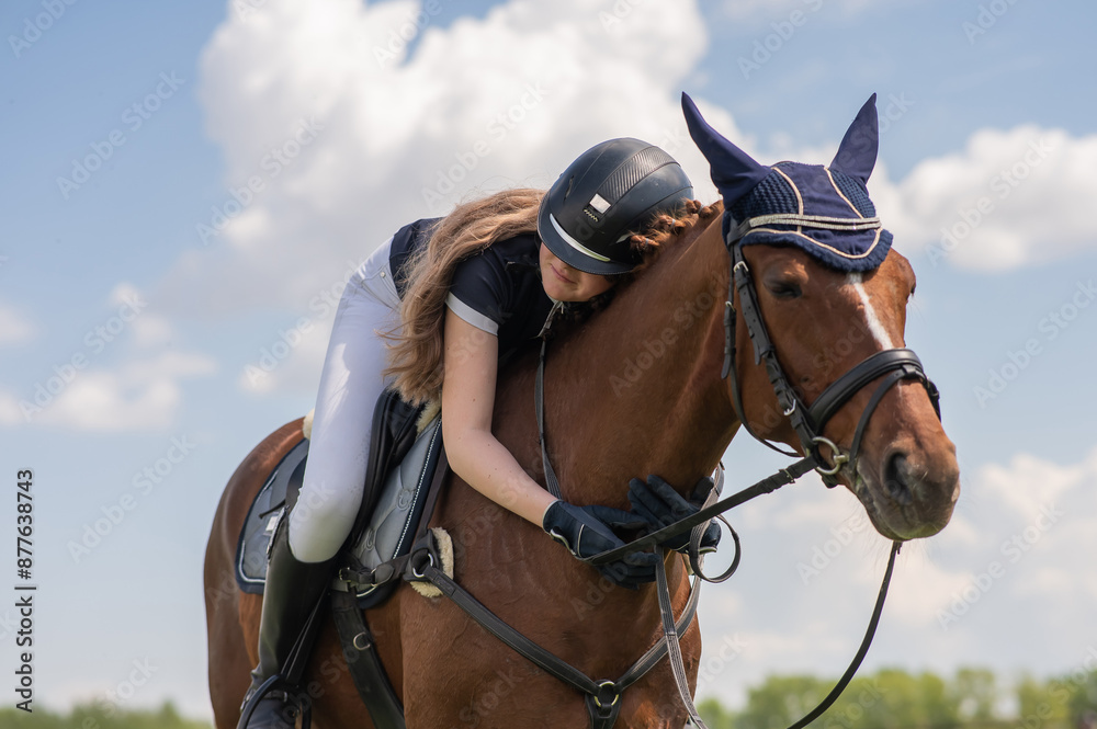 Obraz premium Portrait of a girl jockey hugging her horse.
