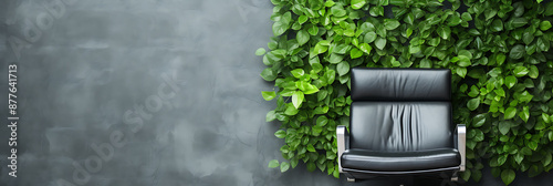 A black leather chair against a lush green wall, representing a modern and serene workspace. 
