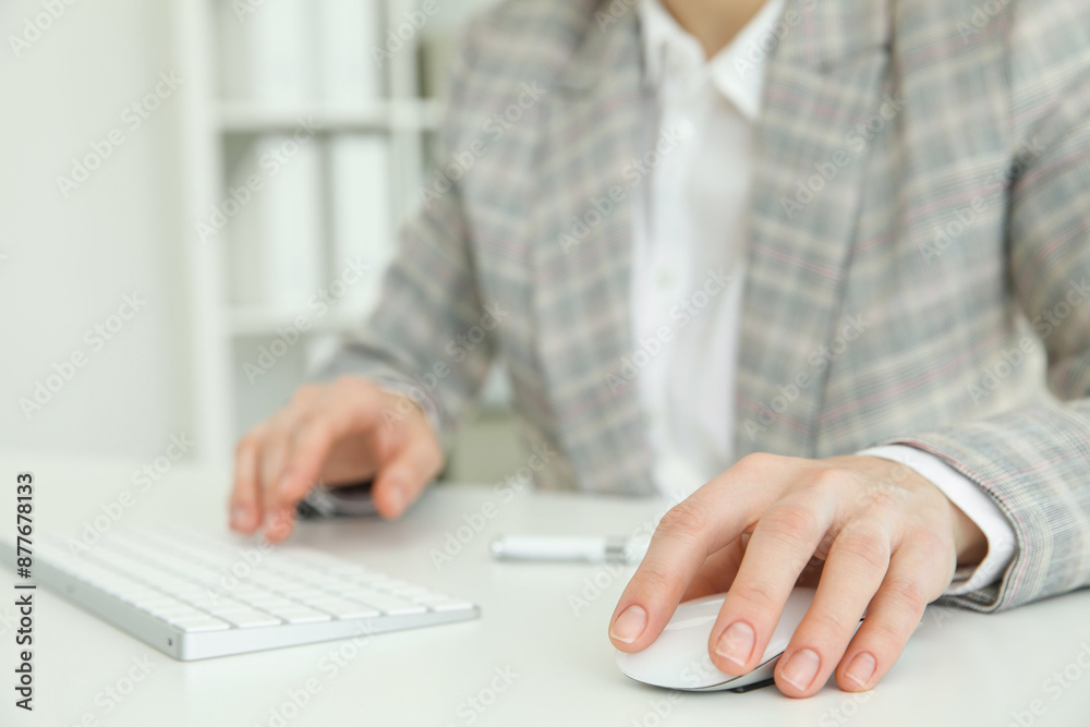 Woman working with wireless mouse and computer keyboard at white table indoors, closeup Woman working with wireless mouse and computer keyboard at white table indoors, closeup