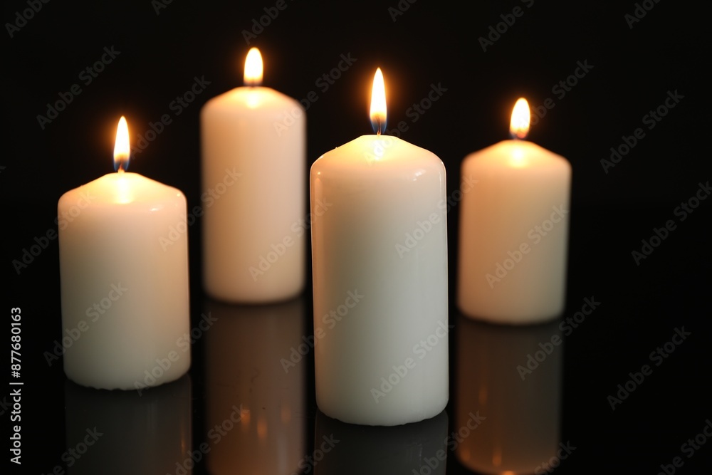 Many burning candles on mirror surface against black background Many burning candles on mirror surface against black background