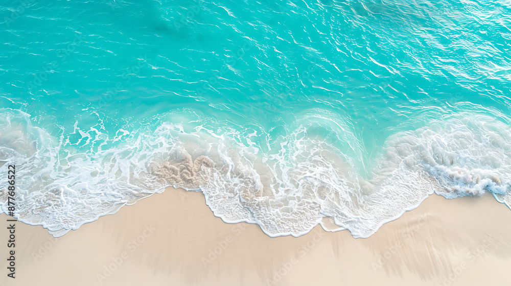 Obraz premium Turquoise water and white foam crashing on a sandy beach, perfect for summer vacation and travel. 