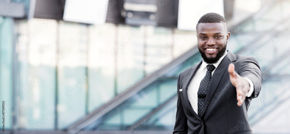 Fototapeta premium Business Networking. Successful Afro Businessman Stretching Hand For Handshake Greeting In Urban Area. Copy Space, Shallow Depth.
