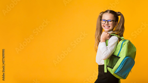 Schoolgirl Posing With School Backpack Smiling To Camera Standing Over Yellow Background. Studio Shot