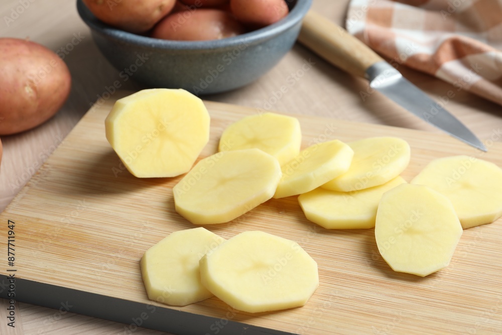 Fresh raw potatoes and knife on wooden table Fresh raw potatoes and knife on wooden table