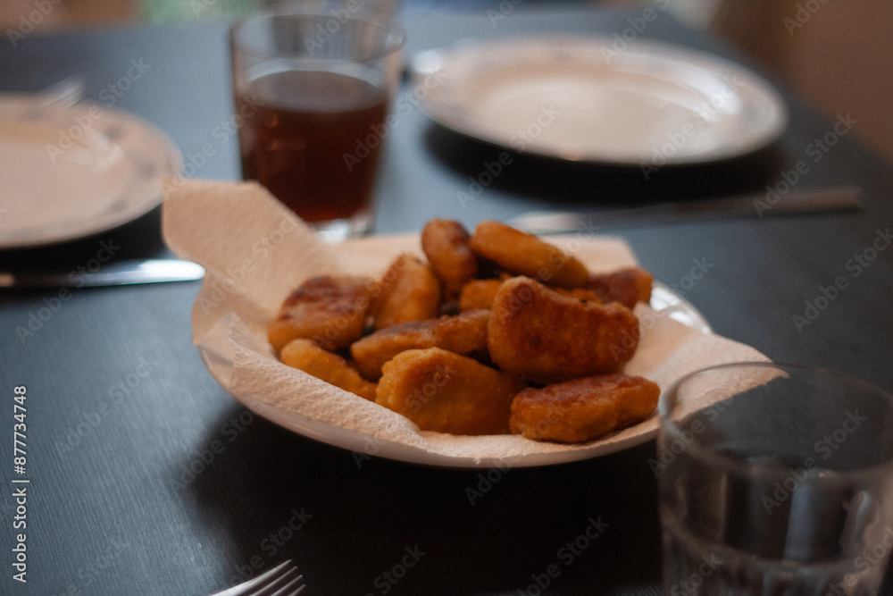 Fototapeta premium dinner table with chicken nuggets, sausages, fries and salad.