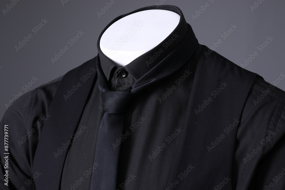 Male mannequin dressed in stylish black suit on grey background, closeup Male mannequin dressed in stylish black suit on grey background, closeup