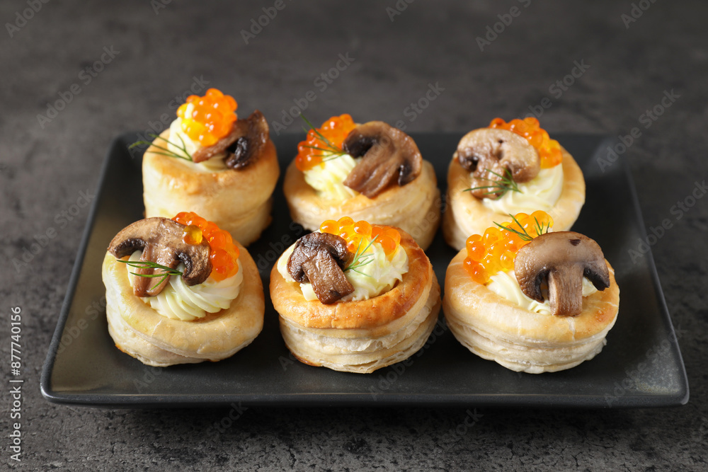 Delicious puff pastry with cream cheese, red caviar, mushrooms and dill on grey table Delicious puff pastry with cream cheese, red caviar, mushrooms and dill on grey table