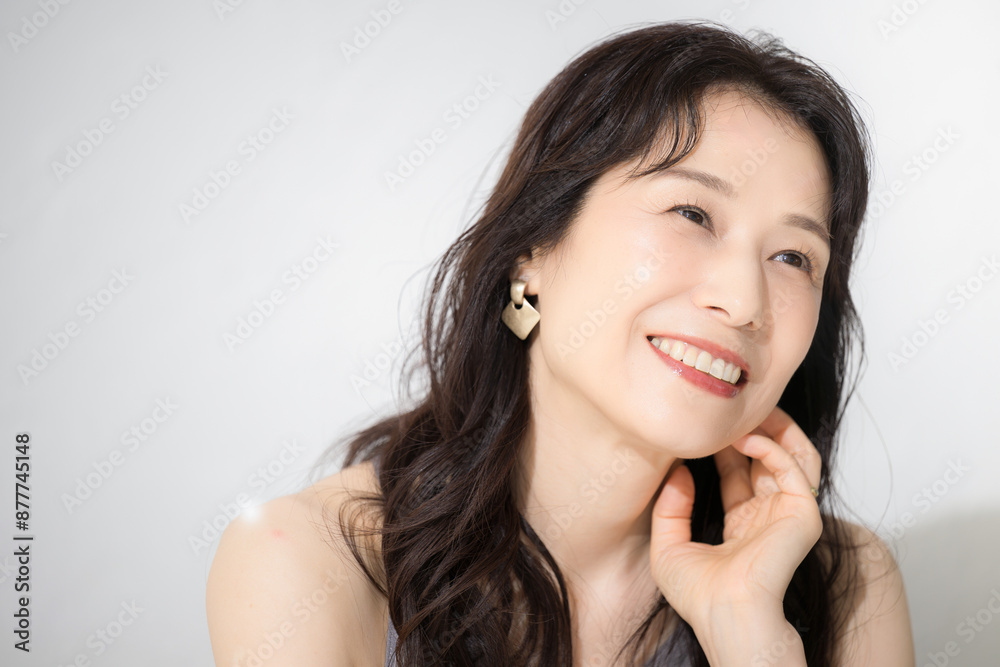 頬に手を触れる女性 美容やビューティーなどに 40代や50代の美しいスキンケアなどの健康的なイメージに 頬に手を触れる女性 美容やビューティーなどに 40代や50代の美しいスキンケアなどの健康的なイメージに