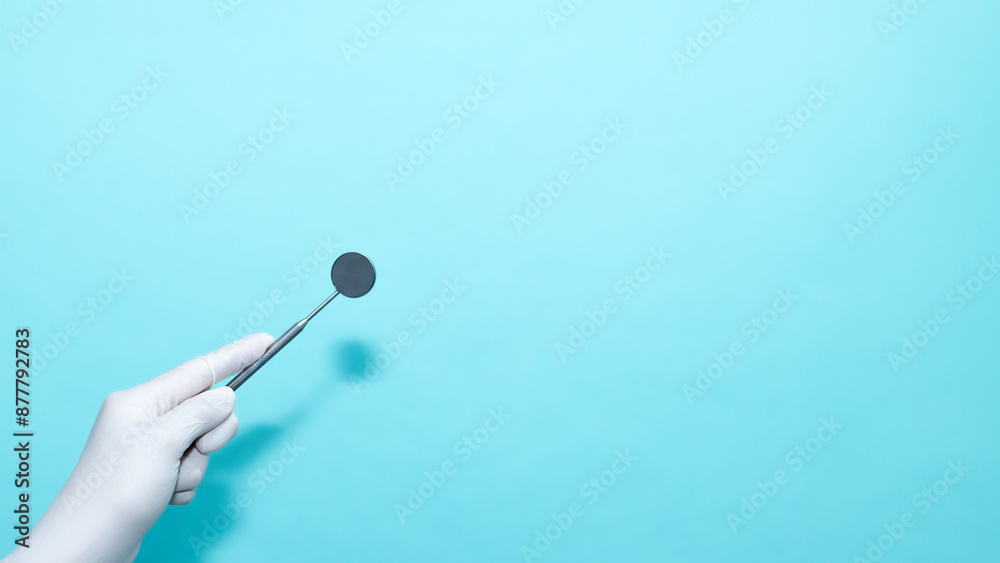 Dentist Holding Dental Mirror instrument isolated on Blue Background Dentist Holding Dental Mirror instrument isolated on Blue Background