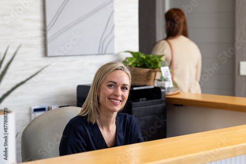 Welcoming patients, smiling receptionist at medical clinic front desk photo