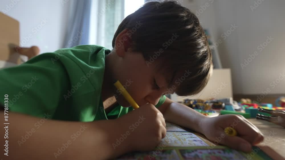 Young Boy Drawing With Yellow Marker, Lying On Floor In Home Setting, Focused On Coloring Book, Wearing Green Shirt, Engaged In Creative Activity, Natural Light, Childhood Fun Young Boy Drawing With Yellow Marker, Lying On Floor In Home Setting, Focused On Coloring Book, Wearing Green Shirt, Engaged In Creative Activity, Natural Light, Childhood Fun