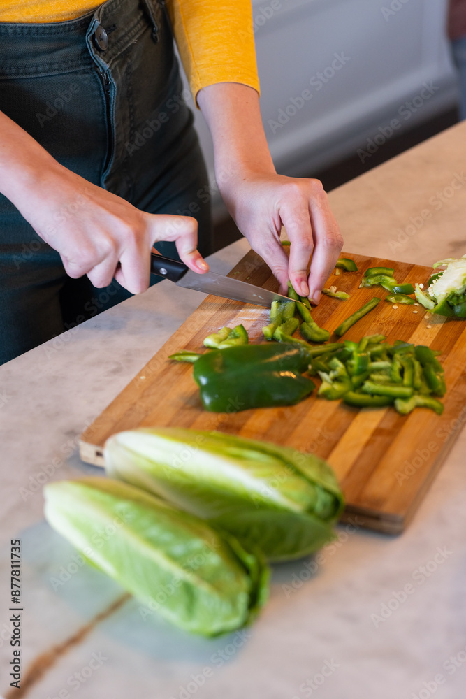 Chopping green bell peppers on cutting board, person preparing fresh vegetables Chopping green bell peppers on cutting board, person preparing fresh vegetables
