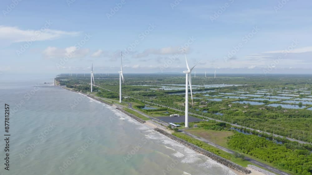 Aerial view of wind turbines or windmills farm field and sea shore beach in industry factory. water power, sustainable green clean energy, and environment concept. Nature innovation. Aerial view of wind turbines or windmills farm field and sea shore beach in industry factory. water power, sustainable green clean energy, and environment concept. Nature innovation.