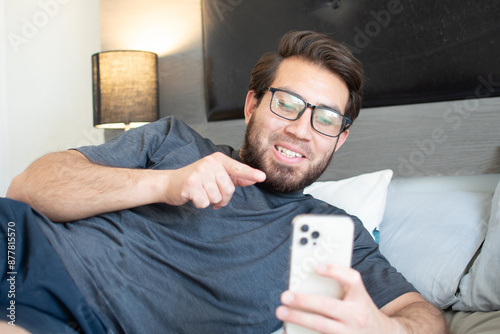 Joven apuesto tomando una videollamada en su teléfono celular 