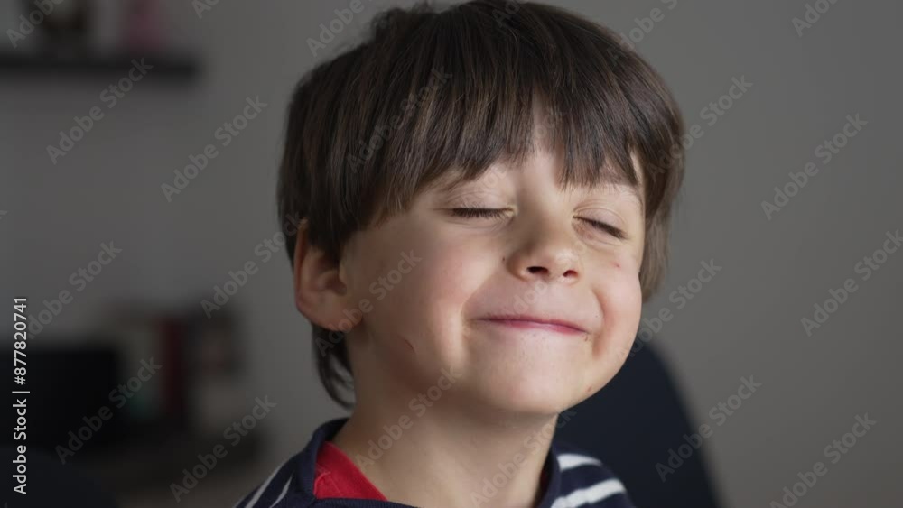 Young Boy With A Mischievous Smile And Striped Shirt, Displaying A Playful Expression, Perfect For Themes Of Childhood Fun, Innocence, And Joy, Captured In A Cozy Home Environment