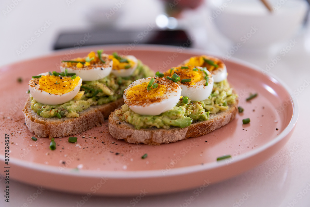 Avocado toast with boiled eggs and chives on pink plate, healthy breakfast option, copy space Avocado toast with boiled eggs and chives on pink plate, healthy breakfast option, copy space