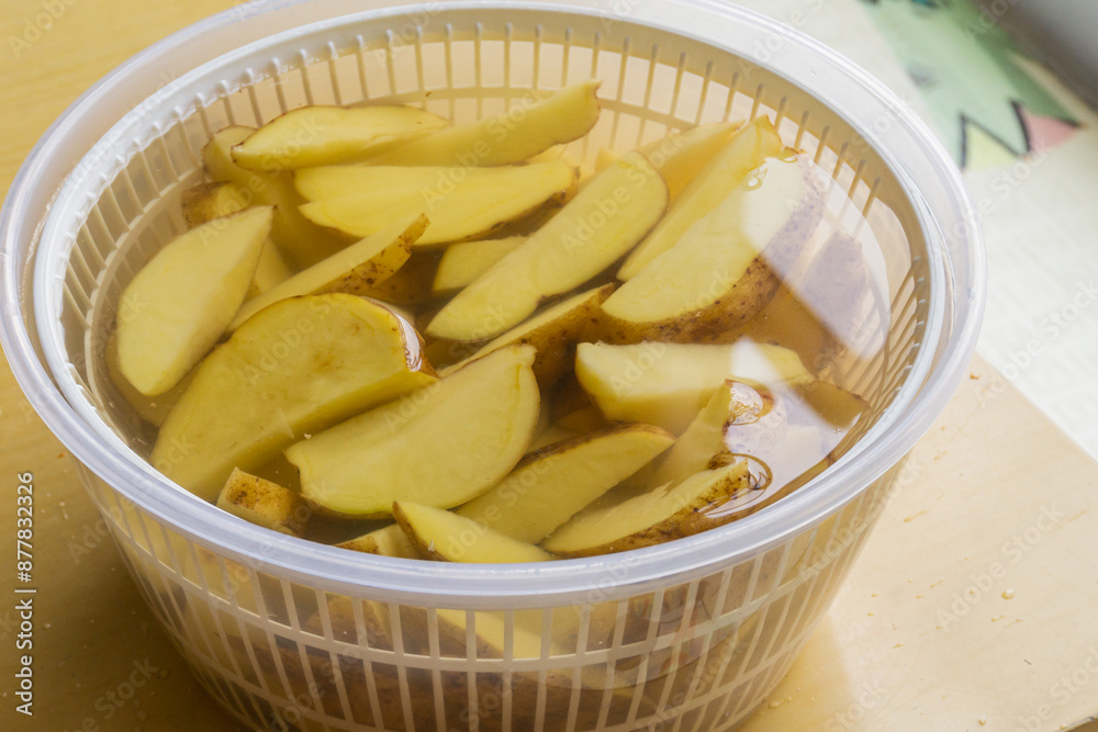 Soaking potato wedges in a bowl of salt water,for flavor and crispyness Soaking potato wedges in a bowl of salt water,for flavor and crispyness