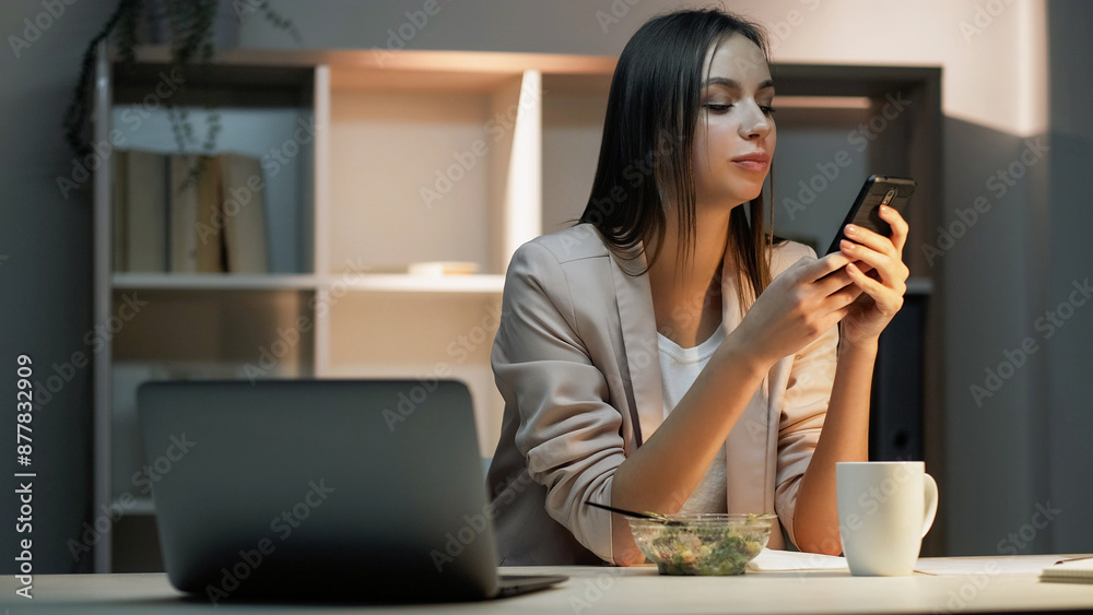 Lunch break. Busy office schedule. Smiling woman worker online texting in social media on phone during dinner time at desk with salad and laptop. Lunch break. Busy office schedule. Smiling woman worker online texting in social media on phone during dinner time at desk with salad and laptop.