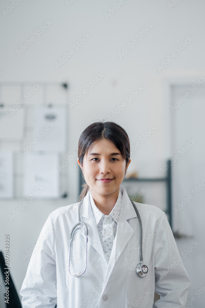 A confident female doctor wearing a white lab coat and stethoscope, standing in a modern medical office with a professional demeanor.