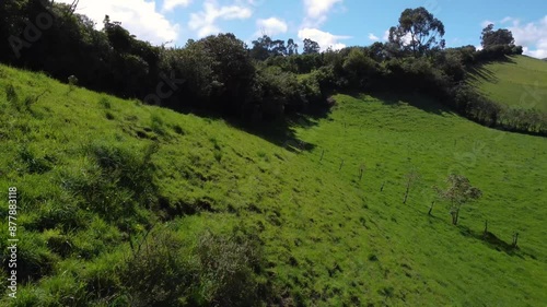 Sunny hillside of greenland province of Pichincha, Ecuador, dolly drone shot with a cloudy sky, copy space photo