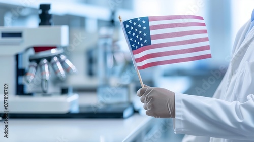 Tribute to Labor Day with a scientist holding an American flag, in front of a blurred laboratory background.