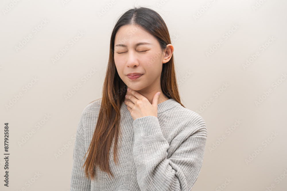 Sickness in inflaming asian young woman, girl use hand check self touch at sore throat, pain thyroid gland on neck or disease reflux, acid of suffer people on wall background. Medical and healthcare. Sickness in inflaming asian young woman, girl use hand check self touch at sore throat, pain thyroid gland on neck or disease reflux, acid of suffer people on wall background. Medical and healthcare.