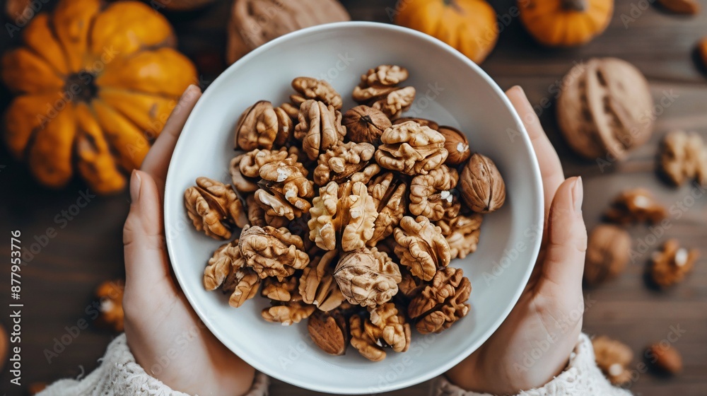 Handful of unshelled walnuts held by a woman on a wooden background, promoting healthy eating and nutrients. Handful of unshelled walnuts held by a woman on a wooden background, promoting healthy eating and nutrients.