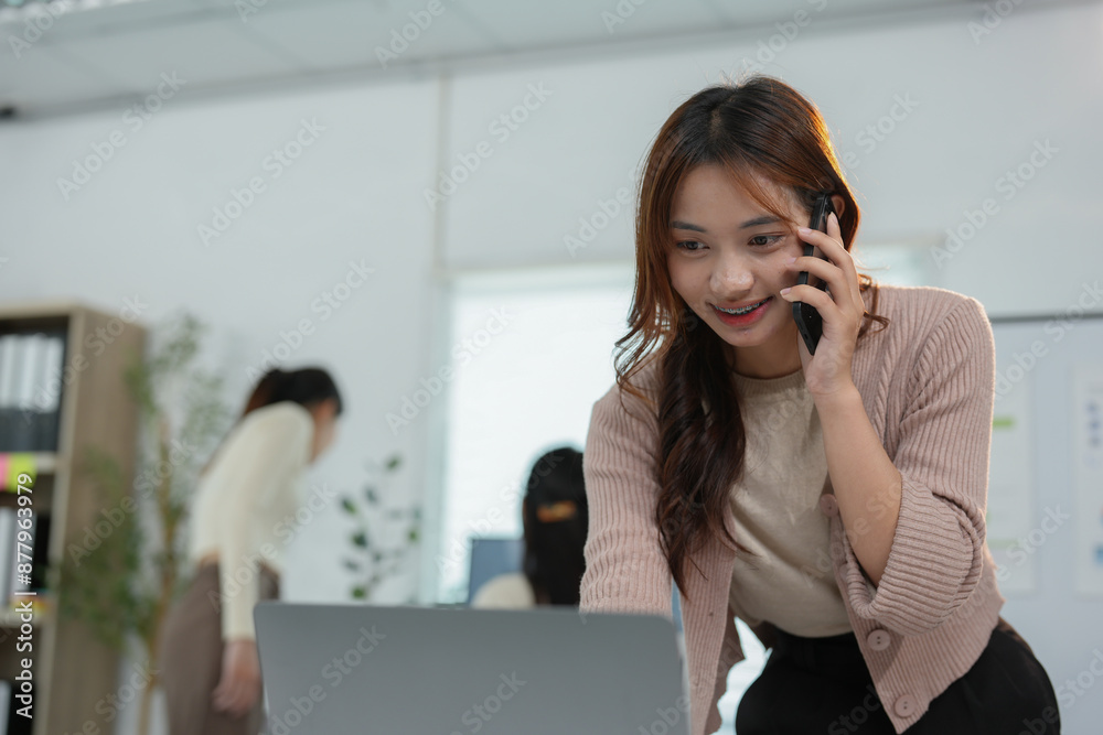 Young young woman with creative Asian business team, office colleagues using smartphone to contact business customers online Successful partnership in teamwork, startup business concept. Young young woman with creative Asian business team, office colleagues using smartphone to contact business customers online Successful partnership in teamwork, startup business concept.