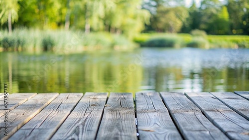 empty grey jetty in foreground of the blurred lakeside background  close-up of an beautiful idyllic waterscape on summer day with advertising space on wooden planks