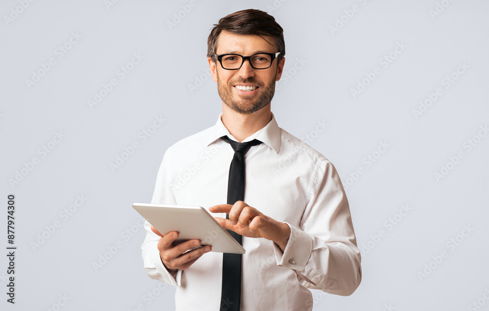Positive Businessman Using Digital Tablet Standing Over White Background In Studio. Empty Space, Isolated Positive Businessman Using Digital Tablet Standing Over White Background In Studio. Empty Space, Isolated