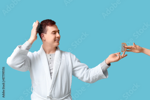 Young man using hair scalp ...