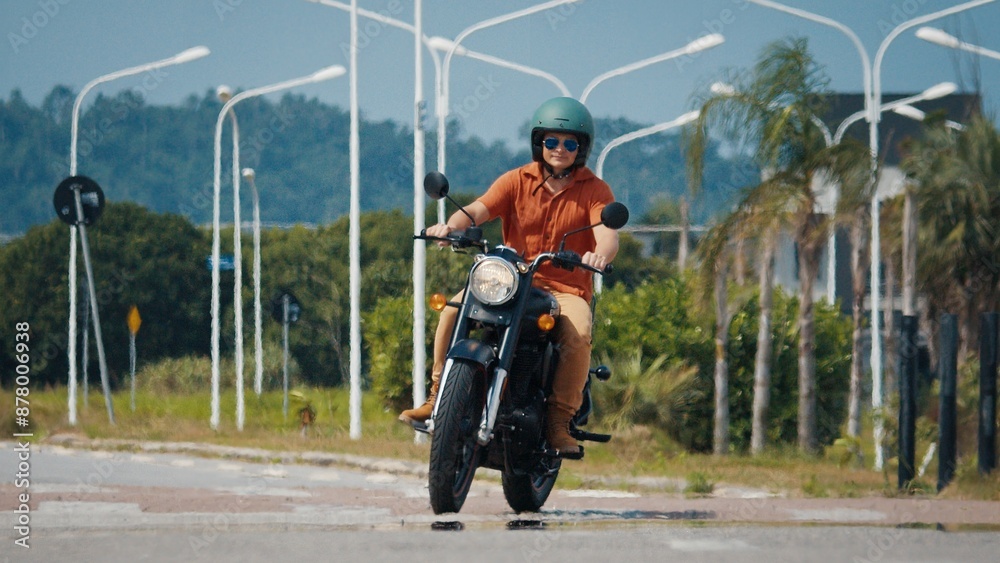 Obraz premium Man rides the classic black motorcycle in urban area