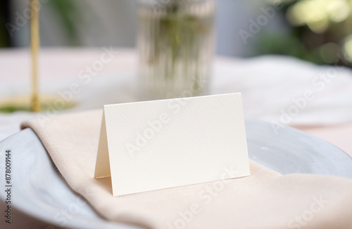 Mockup white blank space card, for Name place, Folded, greeting, invitation on wedding table setting background. with clipping path photo