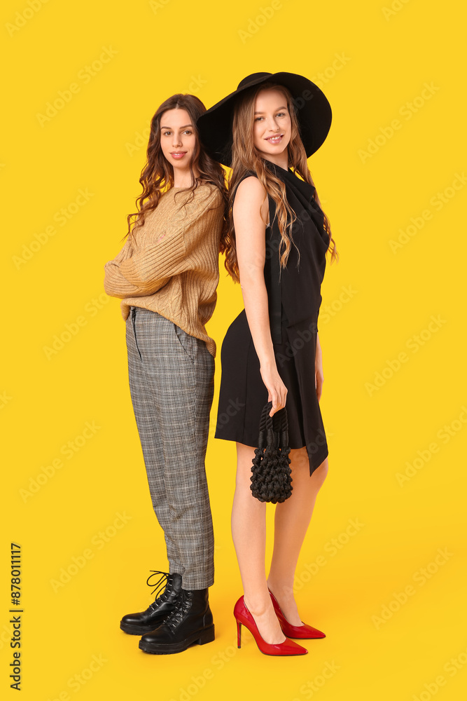 Beautiful young sisters on yellow background Beautiful young sisters on yellow background