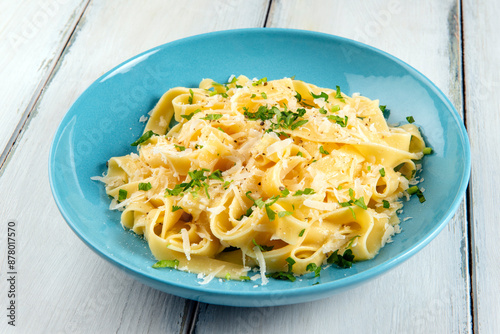 Piatto di deliziose fettuccine Alfredo, ricetta tipica di pasta all'uovo condita con burro e parmigiano, cibo italiano  photo